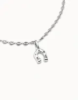Charm en forma de herradura con acabado metálico brillante, diseñado para personalizar collares o pulseras.