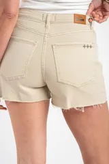 Short de denim color beige, tiro alto, con bolsillos delanteros y traseros, presillas para cinto y botamanga con terminación deshilachada.