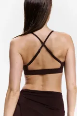 Top deportivo SculptMove color marrón, con escote redondo, breteles finos cruzados en la espalda y bajo elástico. Cuenta con copas forradas con relleno extraíble.