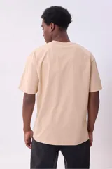 Remera color beige de corte recto y mangas cortas.