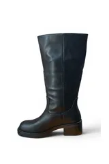 Bota alta de cuero sintético negro, con caña slouchy y taco cuadrado de altura media con plataforma.