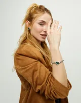 Pulsera elástica de bolas plateadas con un cristal facetado verde.