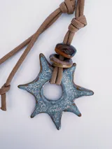 Charm para bolso o accesorios con mosquetón metálico, tejido de macramé en cordón negro y dijes de cerámica esmaltada en tonos violeta y celeste.