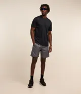 Bermuda deportiva gris para hombre, con cintura elástica, cordón de ajuste, bolsillos laterales y recortes laterales con red. Confeccionada en poliéster.