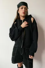Campera negra con cierre frontal, capucha y mangas largas con aberturas en los hombros.