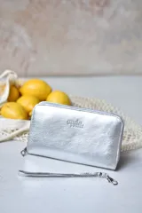 Billetera plateada con cierre de cremallera y correa de muñeca extraíble.