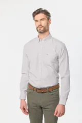 Camisa de manga larga a cuadros pequeños en tonos celeste y blanco, con bolsillo en el pecho y cuello abotonado. Corte slim fit hasta talle XL, a partir de XL classic fit.