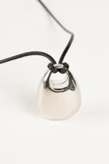 Collar con dije plateado en forma de gota y cordón negro.