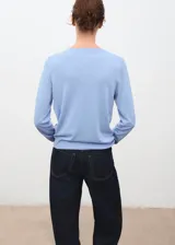 Jersey de punto fino color celeste con cuello redondo y diseño recto de manga larga.
