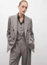 Blazer de corte recto y diseño estructurado, confeccionado en tejido mezcla de lana. Presenta cuello con solapas de muesca, cierre frontal de doble botonadura, bolsillos laterales con solapa y bolsillo de ribete en el pecho. Incluye forro interior y mangas largas con puños abotonados.