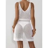 Vestido corto de playa tejido con diseño calado, sin mangas y cuello redondo. Presenta un calce adaptable al cuerpo.
