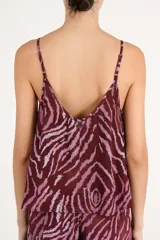 Blusa top de tirantes finos con diseño fluido y estampado animal print estilo cebra en tonos bordó y rosado.