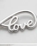 Pulsera de plata 925 con dije central en forma de infinito que incorpora la palabra love en cursiva calada. Cuenta con cadena de eslabones finos y cierre de seguridad.