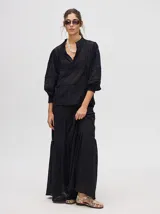 Camisa de broderie de algodón color negro, con diseño de calados, cuello mao con cierre de botones, mangas abullonadas con puños fruncidos y detalles de galones con transparencias.