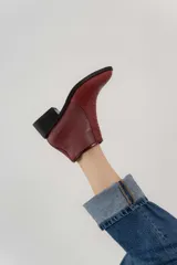 Botas cortas de cuero color marrón claro, con puntera fina y taco bajo de madera.