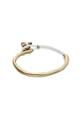 Pulsera semirígida con estructura de cuero color crema y detalle central de mariposa metálica bañada en oro 18k. Presenta un diseño minimalista con el logo de la marca grabado en uno de los extremos metálicos.