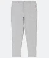 Pantalón de corte slim color gris claro, confeccionado en tejido de poliéster con mezcla de algodón y elastano. Presenta cintura elástica con trabillas, cierre frontal con botón y cremallera, y bolsillos laterales y traseros.