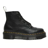Botas tipo borceguí Dr. Martens modelo Sinclair, confeccionadas en cuero texturizado negro. Presentan cierre frontal con cremallera extraíble, cordones, pespunte amarillo característico en la base y suela de plataforma Quad dentada.