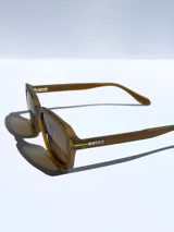 Lentes de sol negros con marco cuadrado y lentes grises.