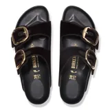 Sandalias Birkenstock modelo Arizona Big Buckle, confeccionadas en terciopelo negro con dos correas ajustables y hebillas grandes de metal dorado. Presentan plantilla anatómica de corcho y suela de goma negra.