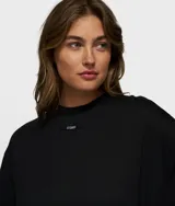 Remera negra de corte oversize con cuello redondo y etiqueta pequeña de la marca en el pecho.