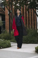 Trench coat reversible de corte recto, con largo por debajo de la rodilla. Un lado está confeccionado en tela impermeable y el otro en viyela suave. Cuenta con bolsillos amplios en ambos lados, lazo de ajuste en la cintura y capucha desmontable.