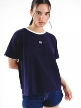 Remera de algodón azul marino, con cuello redondo y detalles en color blanco. Presenta mangas cortas con terminación bordada a contratono y logo bordado pequeño en el frente.