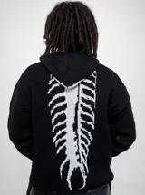 Buzo tejido de punto color negro con capucha, diseño holgado y estampado en la espalda imitando una columna vertebral.