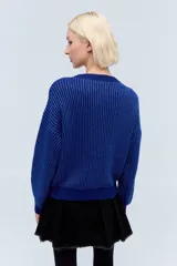 Sweater tejido color gris claro con lurex, cuello redondo y diseño calado.