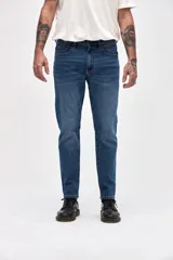 Jean de corte slim, con ajuste en cadera y muslos, y pierna levemente entallada desde la rodilla hasta el tobillo. Presenta un lavado azul medio clásico con costuras reforzadas.