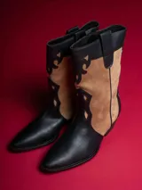 Botas de caña baja color negro con detalles en beige y cierre lateral.