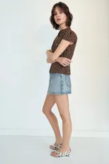 Falda pantalón de tiro medio confeccionada en denim, con bolsillos delanteros y cierre frontal con cremallera y botón metálico.