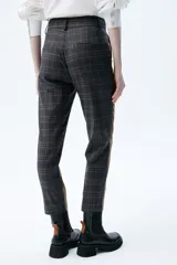 Pantalón de vestir de corte chino, con tiro medio-alto, pierna recta y bolsillos laterales. Diseño a cuadros en tonos marrón, azul y rojo.