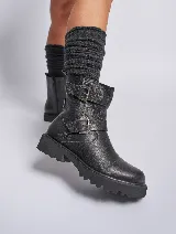 Bota corta negra de cuero con suela track y doble hebilla metálica.