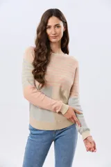 Buzo tejido de algodón con diseño combinado a rayas y bloques de color en tonos beige, salmón y gris, de cuello redondo y manga larga.