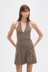 Vestido mini al cuerpo de viscosa con estampado a cuadros, escote halter pronunciado y falda con tablas.