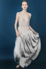 Vestido largo de tirantes con escote redondo, confeccionado en mezcla de viscosa. Presenta un diseño combinado con la parte superior en tejido ligero semitransparente y la parte inferior con volumen y drapeado asimétrico.