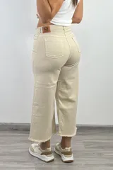 Pantalón culotte color beige con tiro alto, corte ancho, largo a media pierna y terminación desflecada.