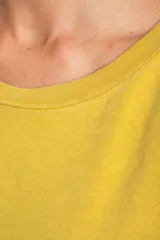 Remera oversize de algodón lavado color mostaza, de manga corta y cuello redondo. Presenta un pequeño bordado en forma de estrella en la parte inferior.