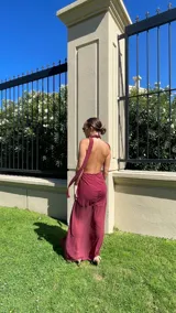 Vestido largo color uva confeccionado en microtul, con escote profundo en V tipo halter y falda con diseño de frunces y transparencias.