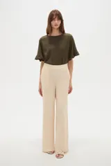 Pantalón de viscosa color beige, de corte ancho, tiro alto y diseño fluido.