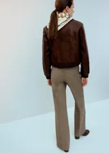 Chaqueta de cuero sintético marrón con textura de efecto reptil, cuello redondo, cierre frontal con botones y puños y cintura elásticos acanalados.