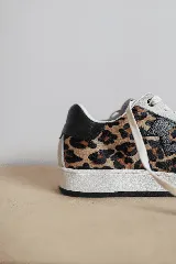 Championes de cuero color blanco con detalle de corona en animal print y talón verde. Cuentan con suela de caucho, lengüeta de gamuza y forro textil, con cierre mediante cordones al tono.