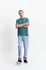 Pantalón jean celeste de corte slim, tiro medio, con pasacintos y confeccionado en algodón con spandex.