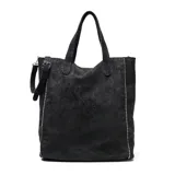 Cartera tipo tote bag de gamuza negra con detalles de tachas metálicas plateadas en los laterales y logo grabado en el centro. Cuenta con doble asa de mano y correa ajustable extraíble.