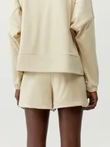 Short deportivo negro de tejido Peach_T extra suave, con bolsillos parche, cordones ajustables y aberturas laterales.