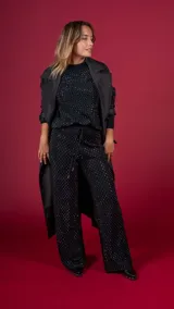 Trench negro con cuello solapa, doble botonadura y cinturón.