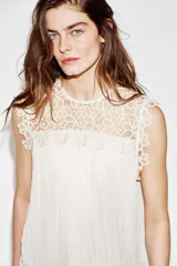 Blusa sin mangas de cuello redondo, con canesú superior de crochet y cuerpo plisado. Cuenta con forro interior y cierre trasero con botón.