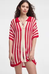 Camisa larga de tejido abierto a rayas verticales rojas y blanco crudo, con cuello tipo polo, mangas cortas y cierre frontal con botones.