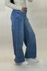 Pantalón de jean estilo wide leg color azul claro, con diseño de costuras diagonales en el frente, tiro alto y cierre frontal con botón.